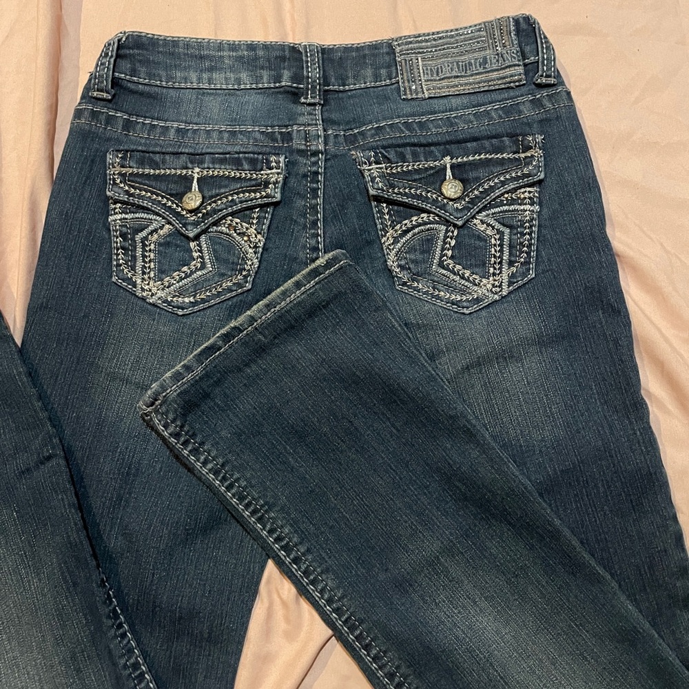 These are low waisted boot cut jeans with white stitching.